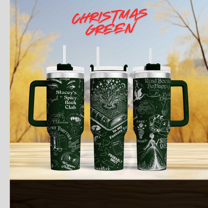 three green tumblers with white text and illustrations on them, set against a blurred background of trees and a blue sky.