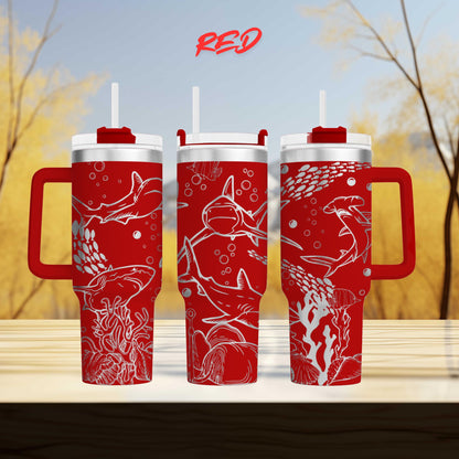 three red tumblers with white shark designs on them, set against a blurred background of trees.