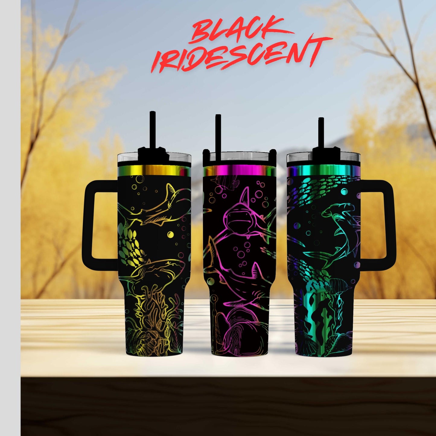 Three colorful, patterned tumblers with handles, arranged on a wooden surface against a blurred background of trees and sky.