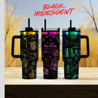 Three colorful tumblers with various designs and text on them, placed on a wooden surface against a blurred background.