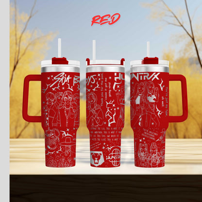 three red tumblers with various designs and text on them, placed on a wooden surface against a blurred background of trees.
