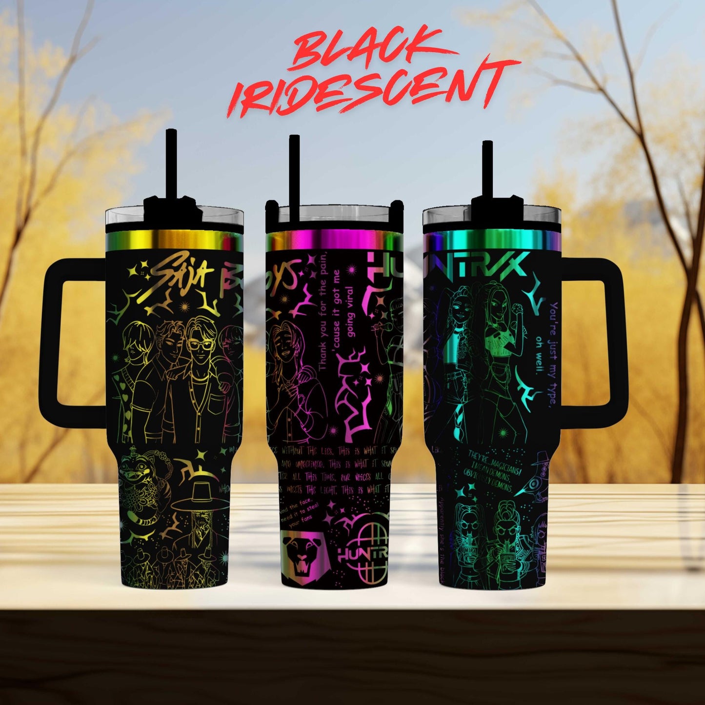 three colorful, patterned tumblers with handles, arranged on a wooden surface against a blurred background of trees.