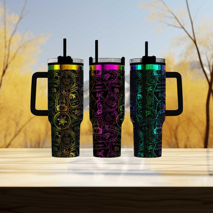 Three colorful, patterned insulated tumblers with handles, arranged on a wooden surface against a blurred background of trees.