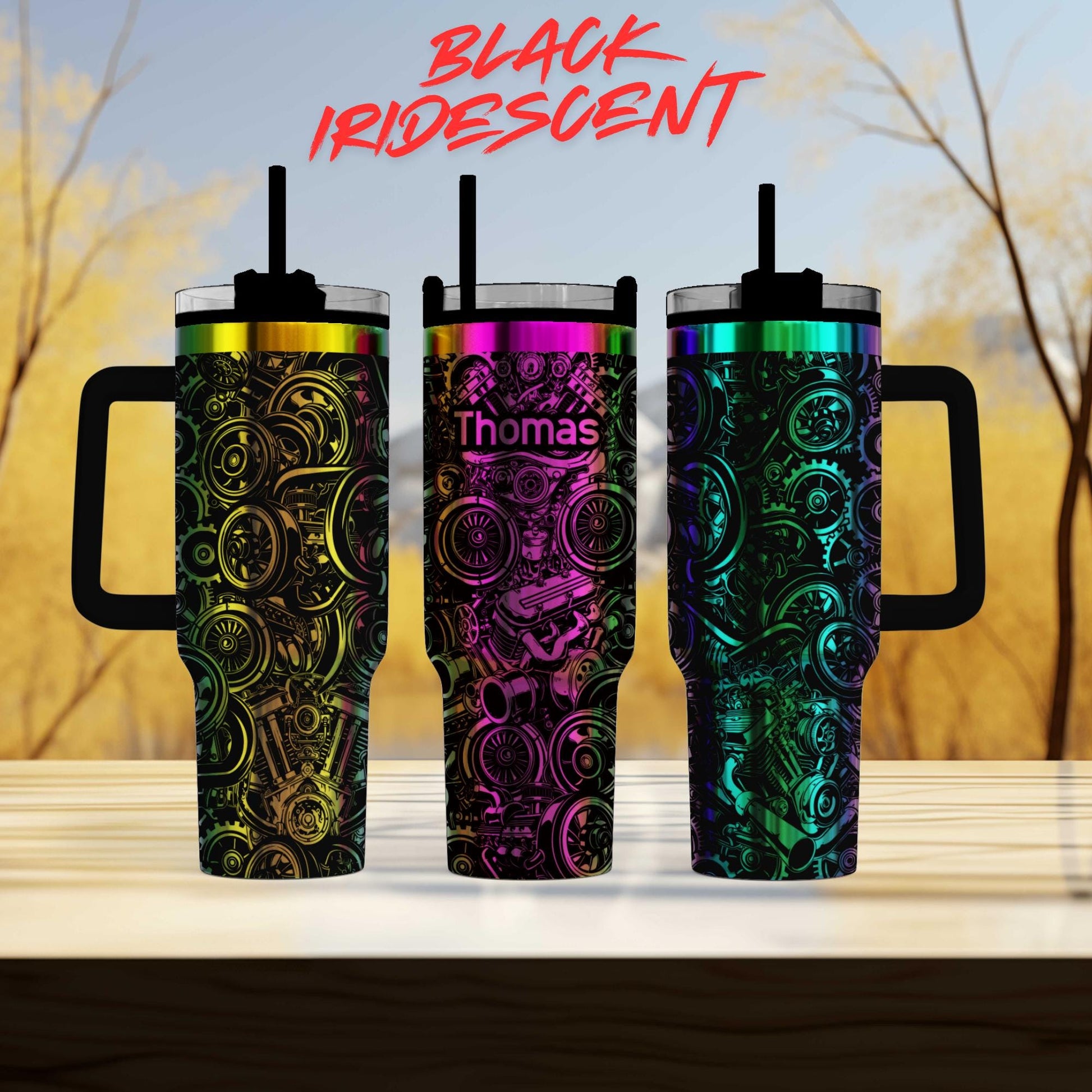 three colorful, patterned tumblers with handles, arranged in a row on a wooden surface.